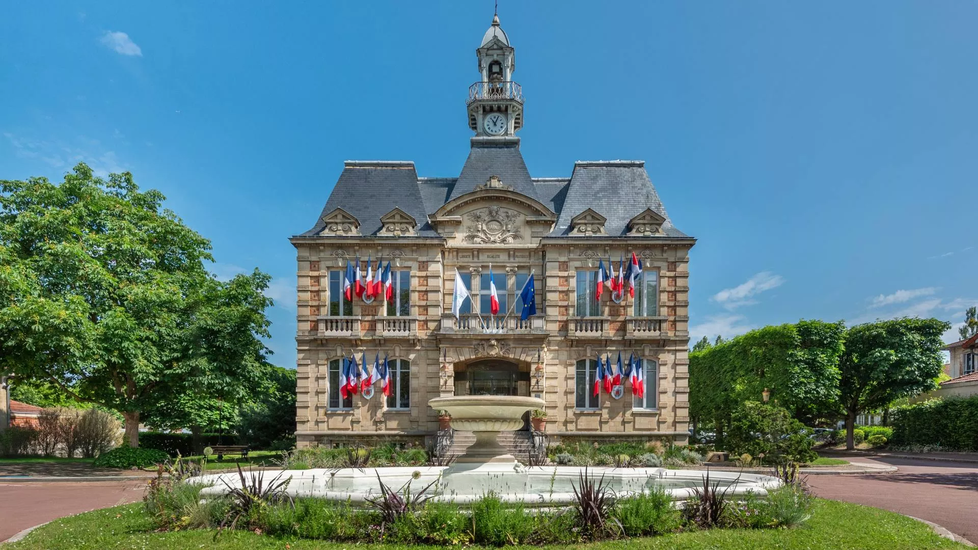 Façade de la mairie du Vésinet, bâtiment emblématique entouré de jardins soignés.