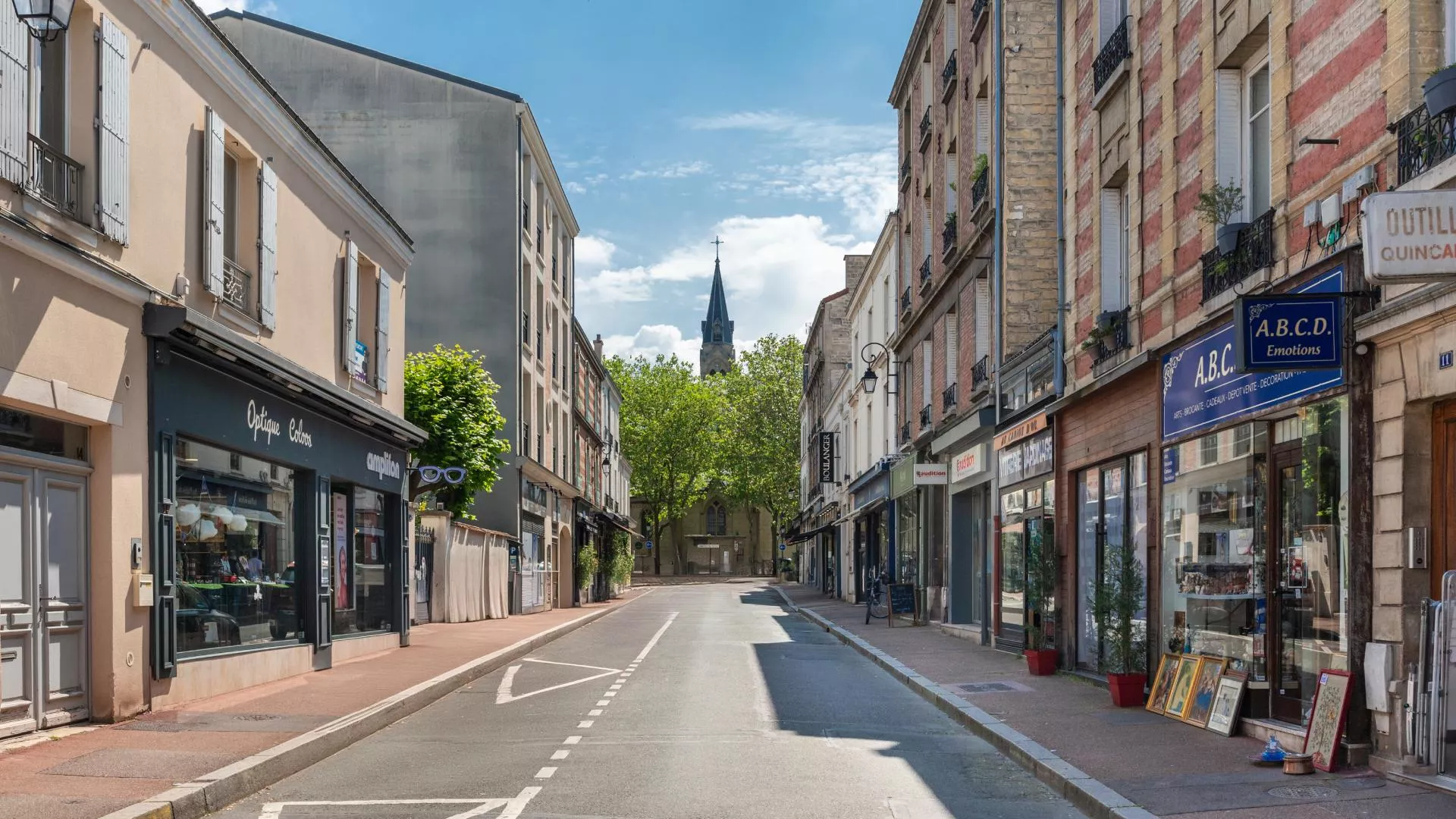 Rue commerçante au Vésinet, bordée de boutiques et d’enseignes locales.