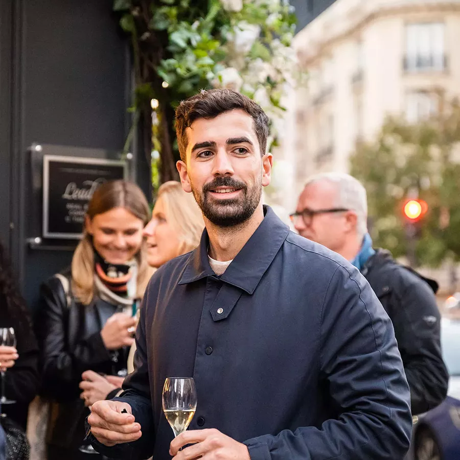 Homme brun qui tient une coupe de Champagne
