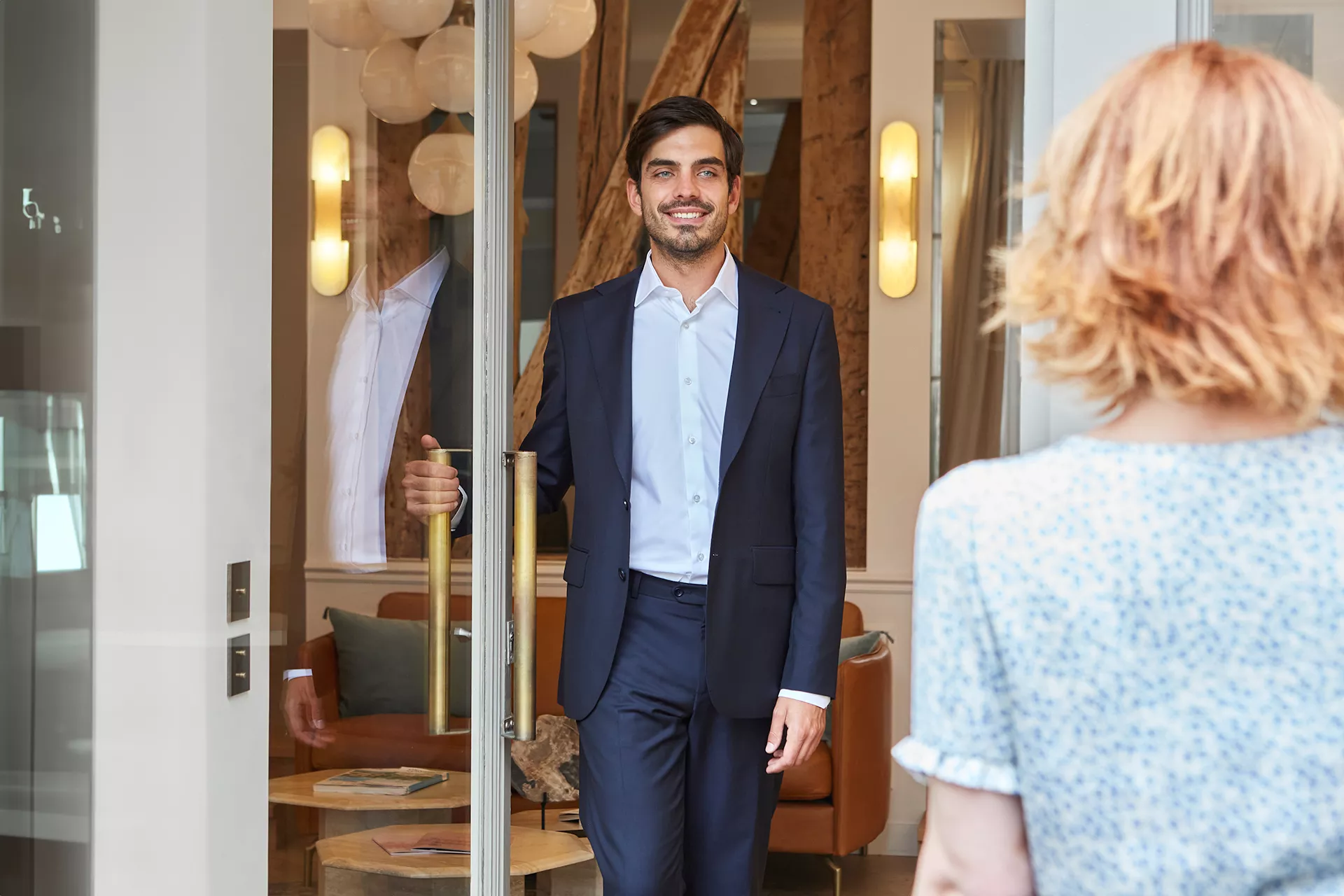 A consultant welcomes a buyer of a luxury property at a Junot agency